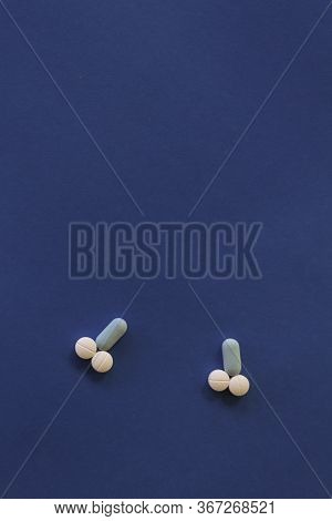 Representation Of Male Genitalia With Pills. Penis Formed With Pills On Blue Background.
