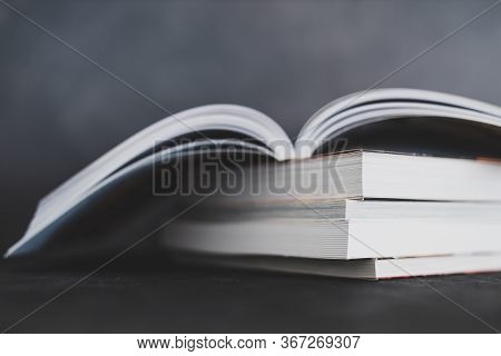 Stack Of Books With One Open On Top Of Themshot From Eye Level With Shallow Depth Of Field