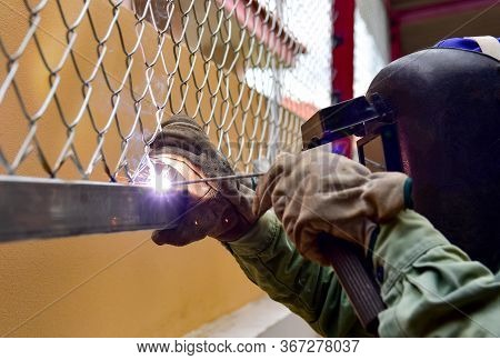 Welder Is Welding The Steel Wire Mesh To Steel Beam By Process Shielded Metal Arc Welding (smaw).