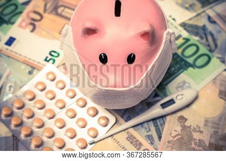 Piggy Bank In A Mask On A Background Of European Currency.the Concept Of Coronavrius Epidemic