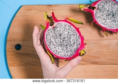Dragon Fruit In The Hands Of A Girl. Slices Of Ripe Pitaya On A Blue Background. Summer Fruit. Pitay