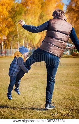 Dad And Son Play In Nature. The Child\'s Emotions And Delight. Warm Sunny Autumn Day In The Park. Fr