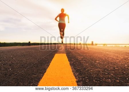 Athlete Running On The Road Trail In Sunset Training For Marathon And Fitness. Motion Blur Of Woman 
