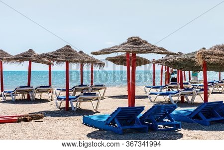Lonely Wicker Sun Umbrella With Two Hammocks On Empty Beach In Fuerteventura. Colorful Turquoise Sea