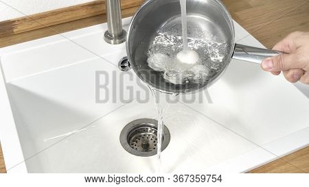 Cooling A Pot And Egg Full Of Hard Boiled Eggs Under Running Tap Water.