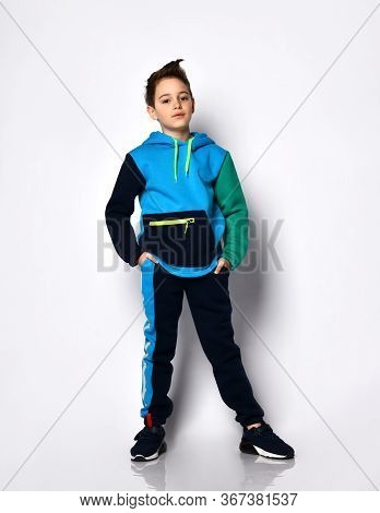 Cute Little Guy With A Stylish Haircut In A Bright Cotton Sports Suit Stands Smiling. Childrens Athl