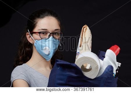 Young Woman In A Valve Of The Respiratory Protective Mask With A Bag Full Of Groceries From The Supe