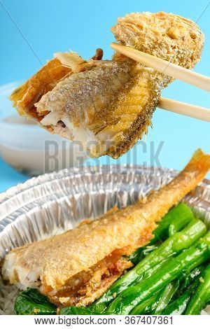 Chopsticks Taking Out Piece Of Larimichthys Or Little Yellow Croaker From Bowl Of Fast Food