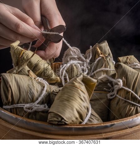Rice Dumpling, Zongzi - Bunch Of Chinese Traditional Cooked Food On Wooden Table Over Black Backgrou