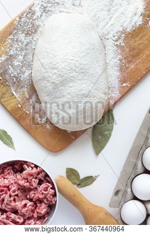 The Dough Lies On The Table, Next To Minced Meat, Eggs, Flour. Dumplings, Russian Cuisine. Sculpt Bu