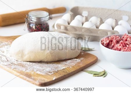 The Dough Lies On The Table, Next To Minced Meat, Eggs, Flour. Dumplings, Russian Cuisine. Sculpt Bu