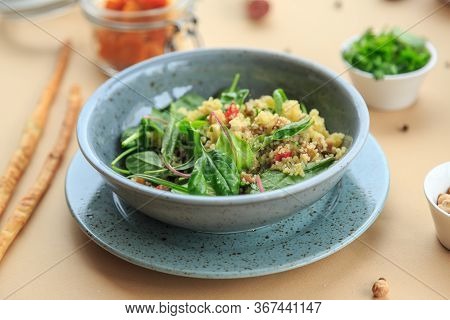 Closeup Of An Earthenware Casserole With Couscous With Chicken And Vegetables On A Rustic Wooden Tab