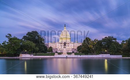 The United States Capitol Building At Twilight Wirth Reflection In Water.