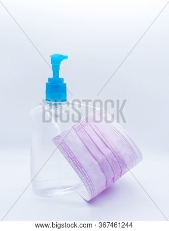 Sanitizer Jel Bottle With Pink Face Masks Isolated On White Background.