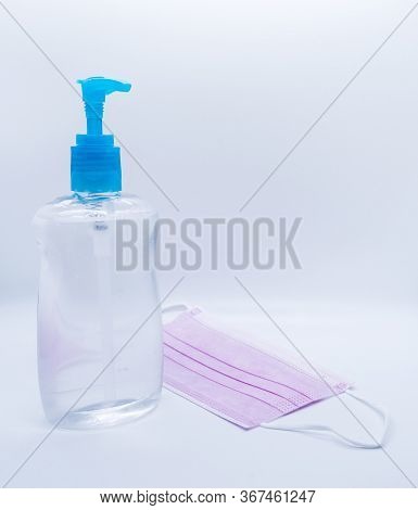 sanitizer jel bottle with pink face masks isolated on white background.
