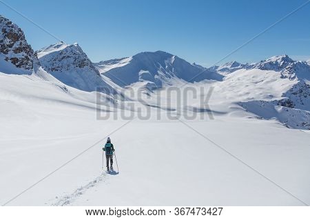One Women With Snowshoes In Snowy Winter Landscape Near Arosa Switzerland With Sandhubel Mountain In