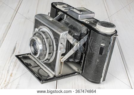 One Whole Opened Vintage Camera On White Wood