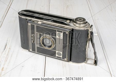 One Whole Closed Vintage Camera On White Wood
