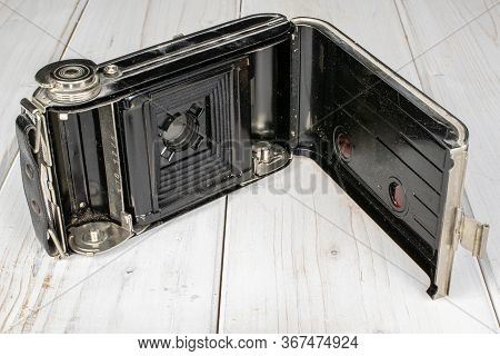 One Whole Opened Vintage Camera On White Wood