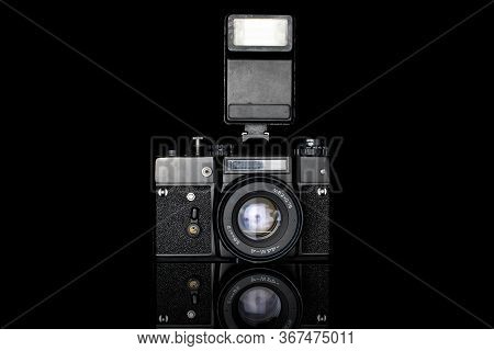One Whole Camera With Flash Isolated On Black Glass