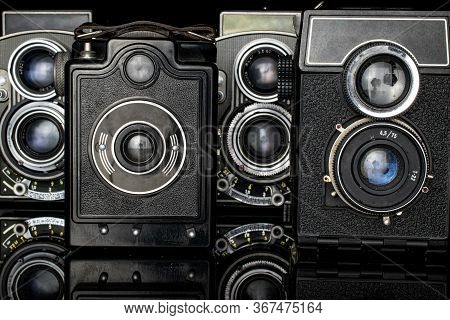 Group Of Four Whole Vintage Camera Isolated On Black Glass