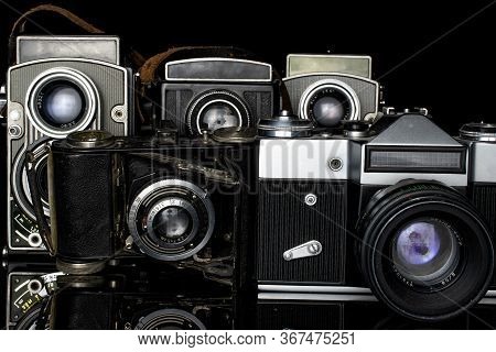 Group Of Five Whole Vintage Camera Isolated On Black Glass