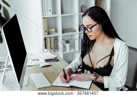 Beautiful Secretary In Bra And Eyeglasses Writing On Notebook In Office