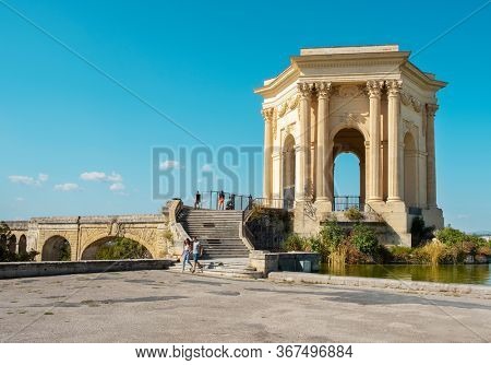 MONTPELLIER, FRANCE - SEPTEMBER 19, 2019: A view of the Promenade du Peyrou garden in Montpellier, France, highlighting the Chateau de eau, its iconic neoclassical water tower, presiding over the pond