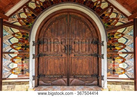 Ancient Gates On The Facade Of The Building And Stained Glass Windows.
