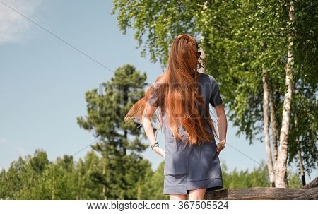 Young Red Haired Woman Showing Long Ginger Hair. Beautiful Slim Woman Unrecognizable, With Very Long