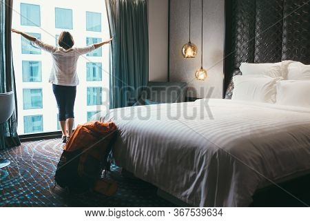 Backpacker Female Accomodating In 5 Stars Luxury Hotel. She Opening A Whole Wall Window Curtains To 