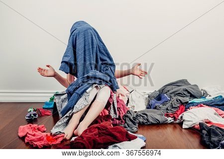 Kid Playing With Face Covered. Cute Caucasian Girl Sorting Clothes. Adorable Funny Child Arranging O