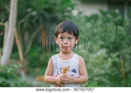 Asia Boy He Mouth Aftertaste From Eating Chocolate Ice Cream  Or Chocolate Dessert. A Sweet-toothed 