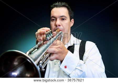 Retrato de um músico tocando a trombeta. Fundo preto.
