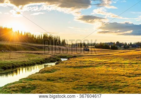 Rural Grassland Landscape In Sunny Spring Evening. Sunset In Jizerka Village With Jizerka River, Jiz