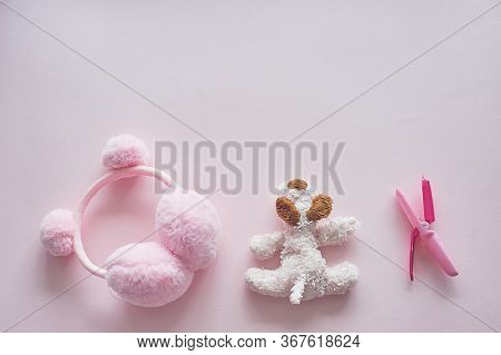 Childrens World Girl. Pink Background, Toy, Curling Tongs And Earbuds With Pumpons.