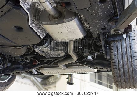 Car On A Lift In A Car Service. View Of The Car From Below.