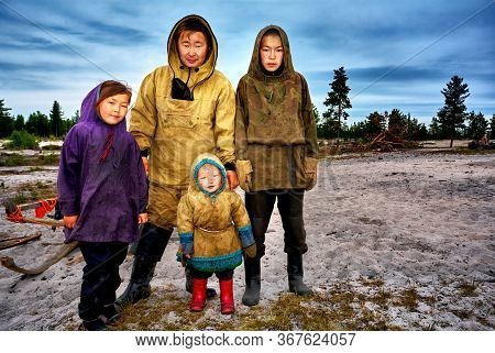 Yamal, Russia - June 2011: Portrait Of Adult Nenets And Children At The Camp, In National, Casual Cl