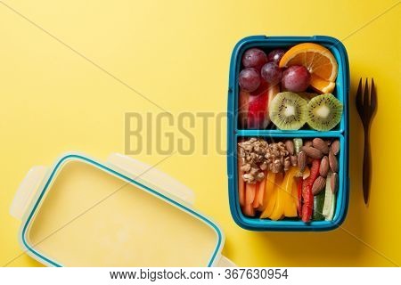 Top View of Full Lunch Box with Fuits, Vegetables and nuts.
