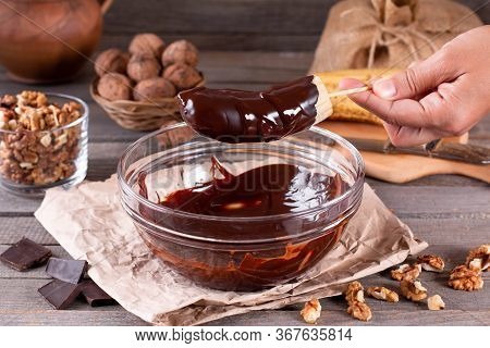 Woman Hands Pour Frozen Banana With Chocolate. Frozen Chocolate Covered Bananas On A Stick