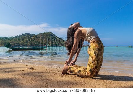 Asian Thai Woman Practicing Yoga At Evening In Haad Chaloklum Beach, Koh Phangan Island, Thailand. C