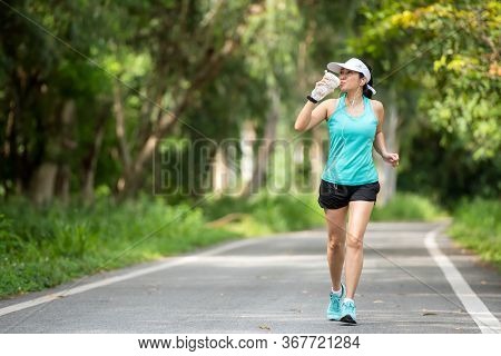 Healthy Woman Jogging Run And Workout And Drink Fresh Water On Road Outdoor. Asian Runner People Exe
