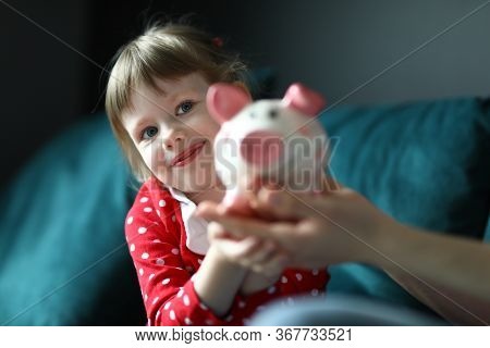 Portrait Of Lovely Little Kid Holding Pink Piggy Bank. Smiling Light Haired Girl Wearing Red Dress I