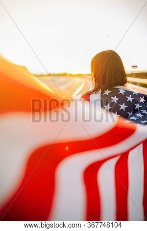Woman Holding Usa Flag. Independance Day In America. 4th July. Girl Walking Along Highway With Wavin