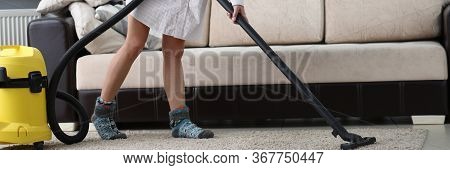 Woman With Mask On Her Face Vacuuming Carpet. Flooring Must Be Cleaned Regularly. In Everyday Condit