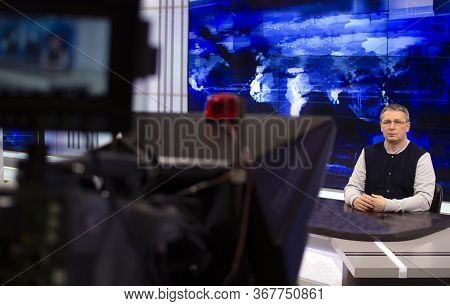 A Male News Anchor In A Broadcast Studio Reads Text On A Teleprompter. Camera In The Tv Studio.