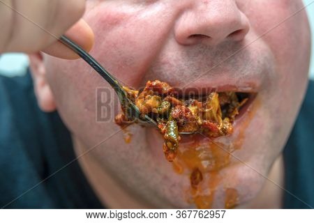 A Hungry And Fat Fat Man Eagerly Eats Roasted Meat With Spices, Fat From His Mouth Flows Through His