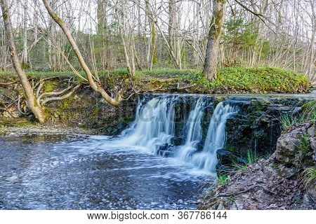 Beautiful View In Spring Of A Waterfall In A Small River