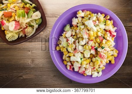 Crab Salad On Purple Plate With Vegetaible Salad Top View. Crabs Salad On Brown Wooden Background
