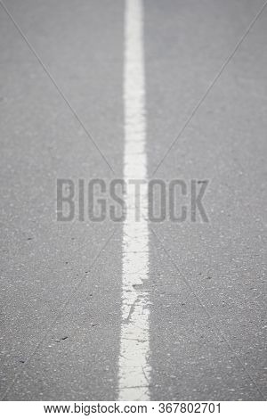 White Continuous Line On Asphalt. Road Marking On The Highway. Selective Focus Of The Line Stretchin